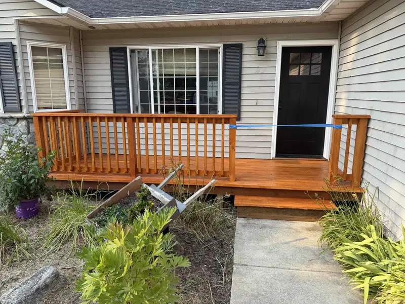 Freshly stained wood deck railing and steps at a home's front entry